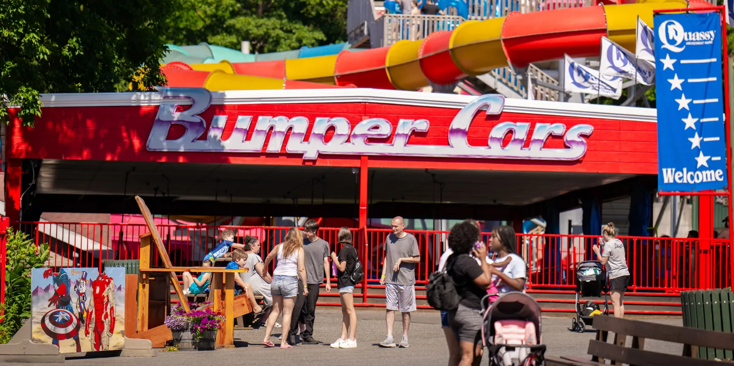 Showing entrance to Bumper Cars ride, with large sign, and people walking around