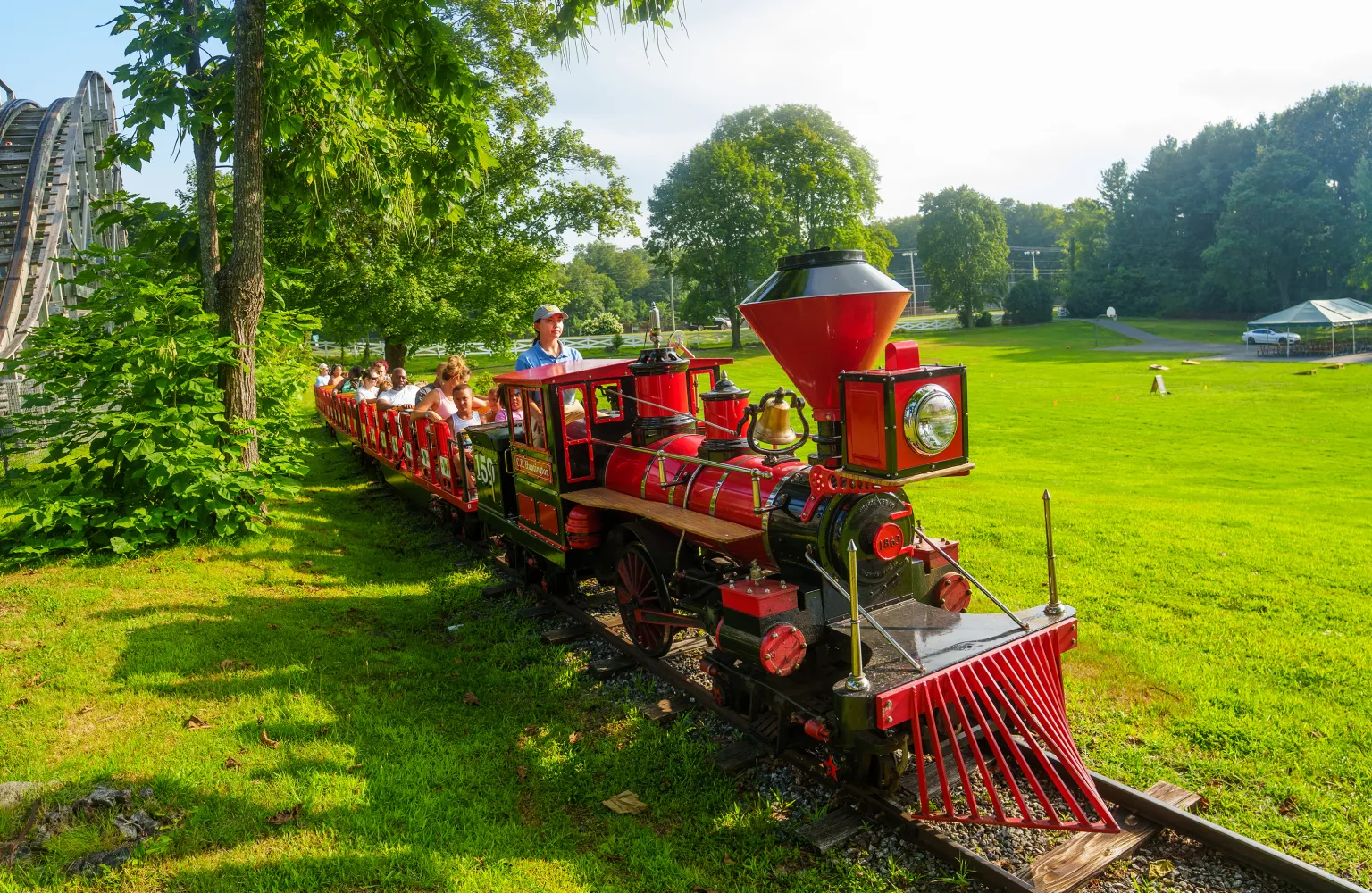 Quassy employee operating train ride with adults and children sitting in seats