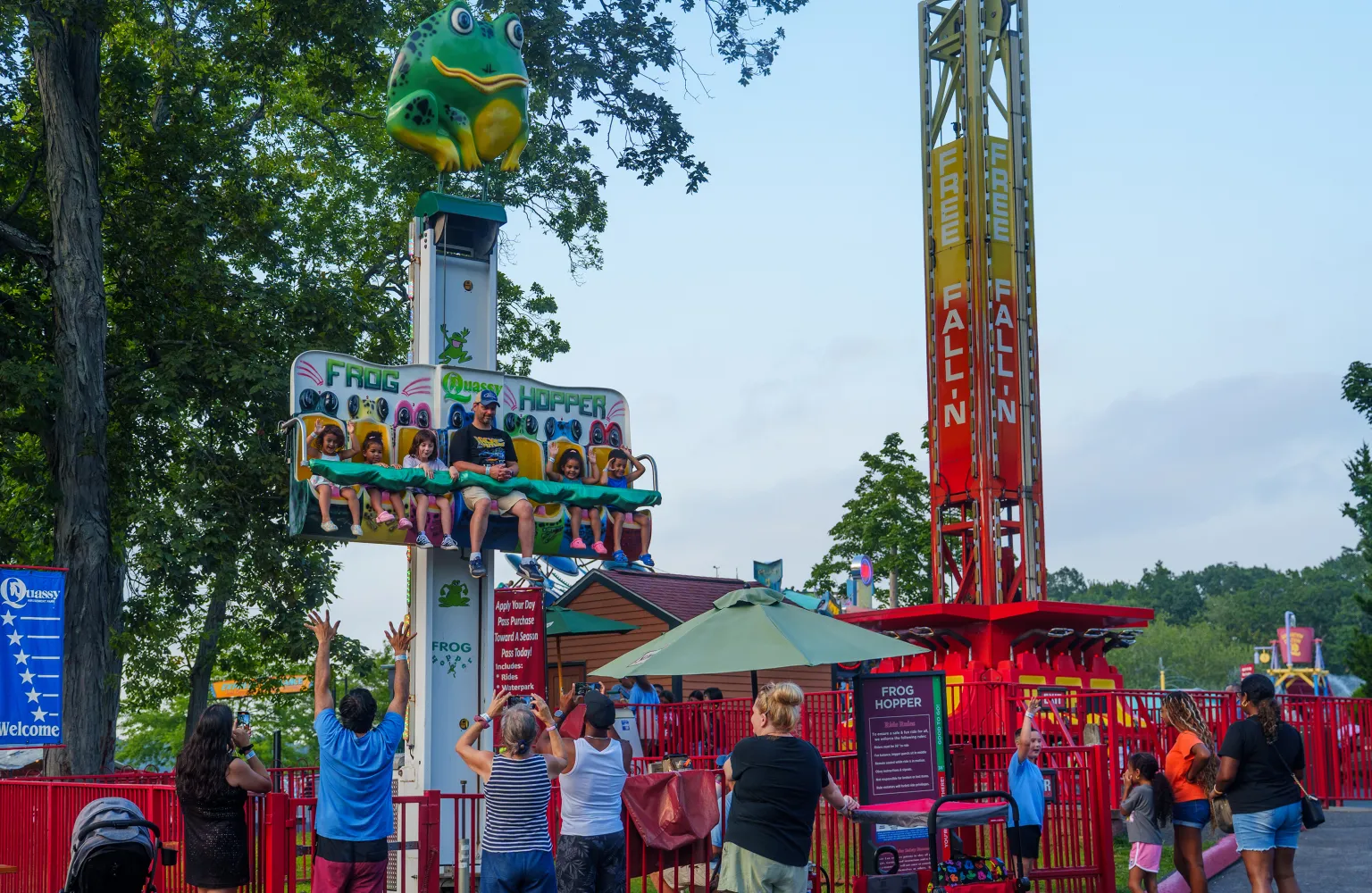 Adult and children on Frog Hopper ride with onlookers