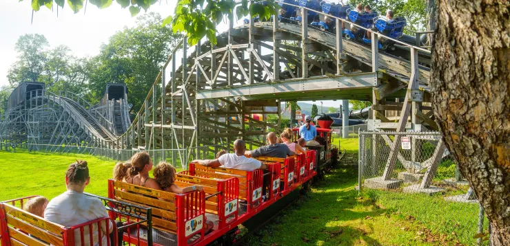Quassy train with people on ride going underneath the Wooden Warrior roller coaster