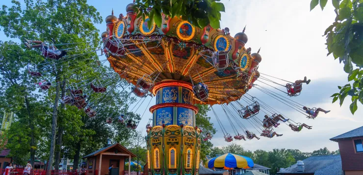 People in swings on Aladdin Wave Swinger ride, spinning