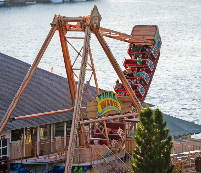 Adults and children riding on Tidal Wave swinging ship ride