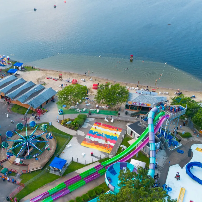Aerial shot of Lake Quassapaug beach, waterpark and water slides, and amusement rides