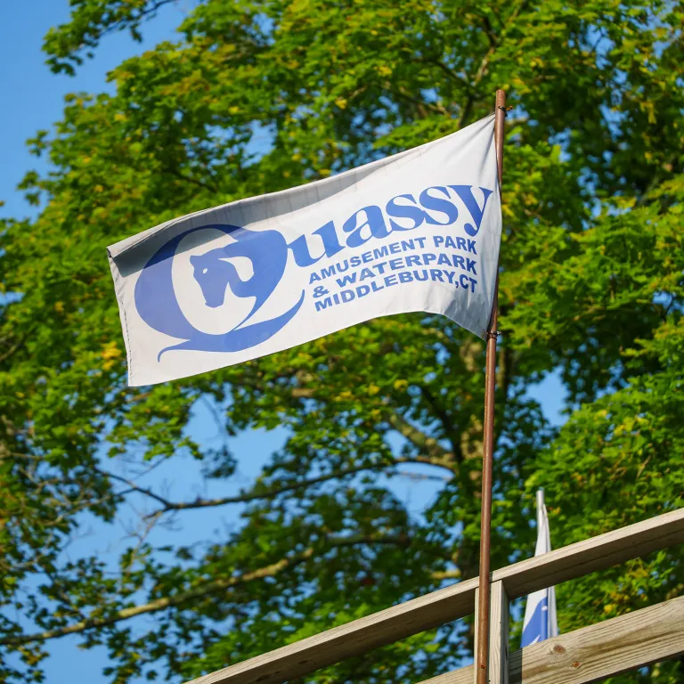 Quassy flag flying in wind with trees in background